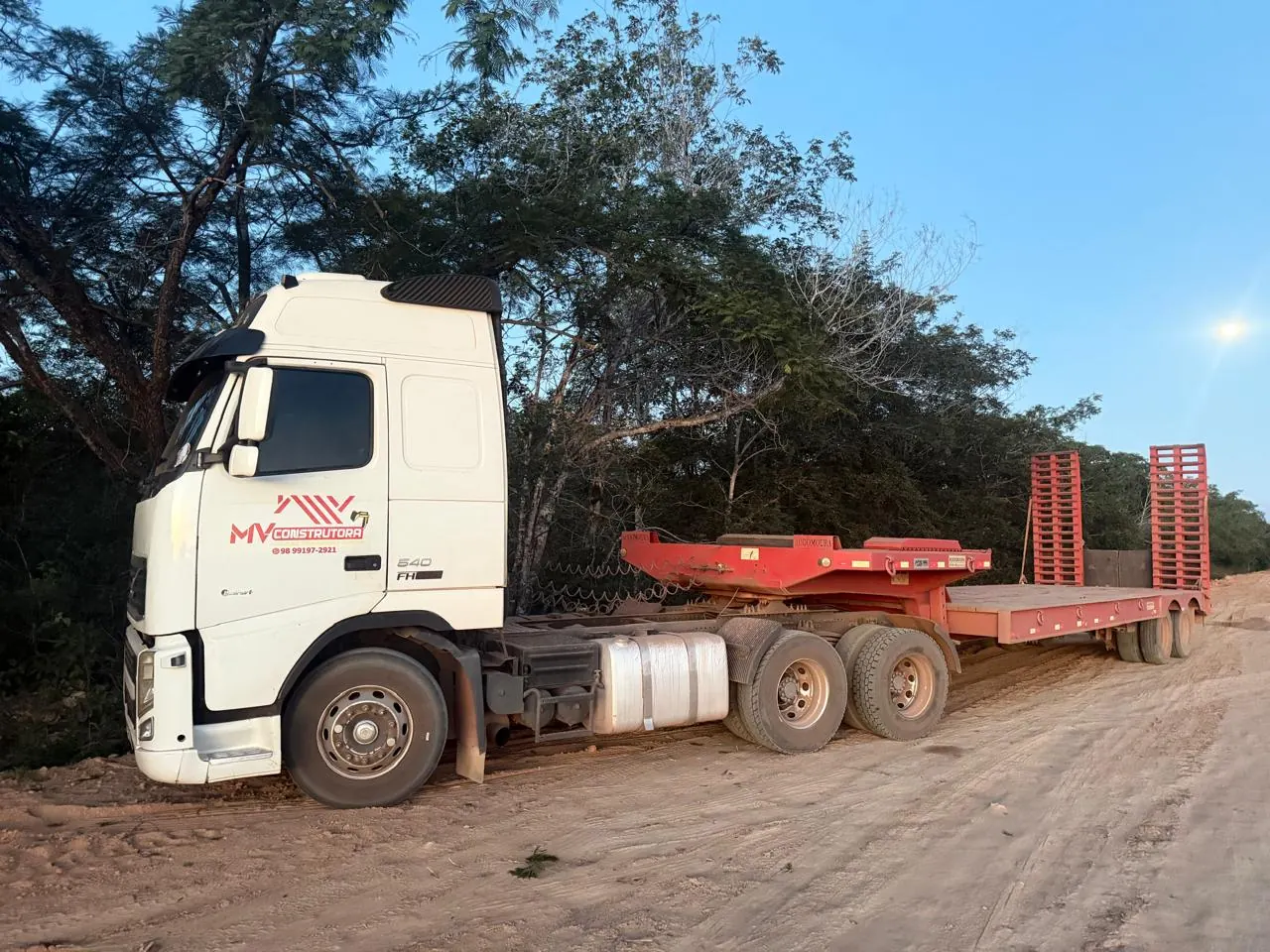 Caminhão prancha da frota do Grupo MV Construtora em operação