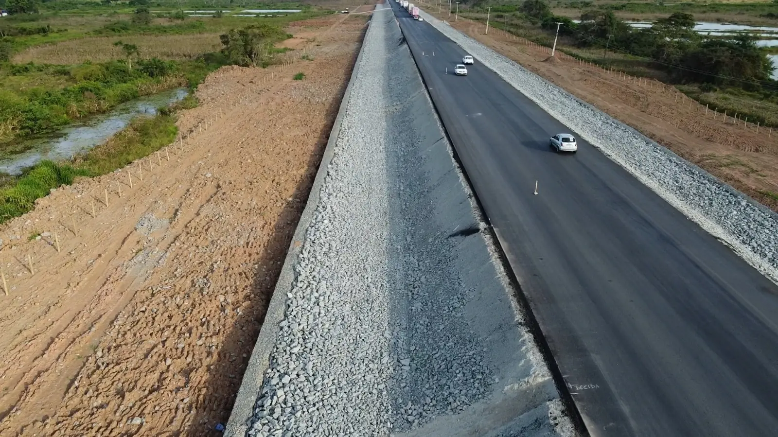 Vista aérea da BR-316 em recuperação, com aterro da plataforma e contenção em pedra ao lado da pista